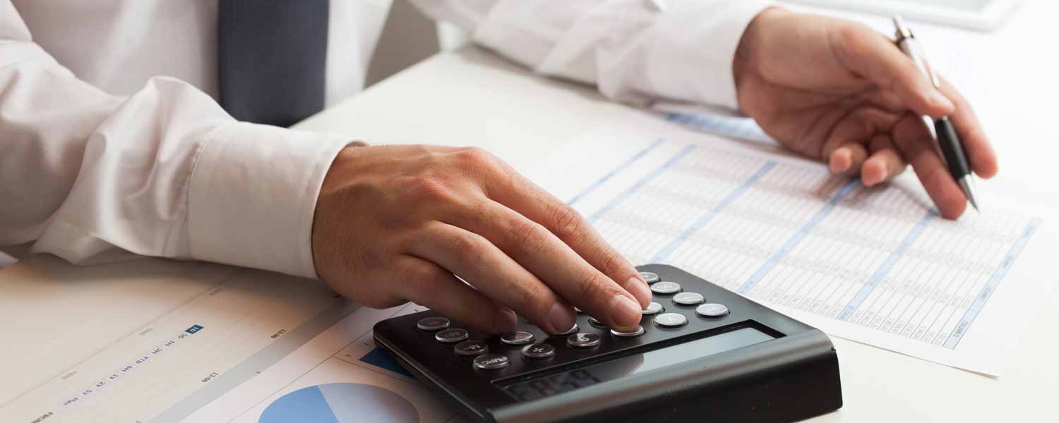 Homem usa calculadora para calcular o Imposto de renda